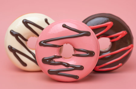 Close-up of glazed donuts on a pink background