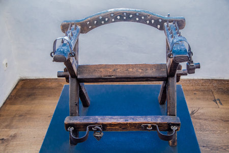 Wooden torture chair, armrests and backrest of a chair with spikes.