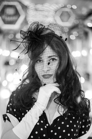 Moscow, 2019, GUM, Red Square. Photo shoot in retro style. A girl in a retro polka dot dress, white gloves and a veil on Moscow's red Square. Photo shoot in the style of the 80s and 90s.のeditorial素材