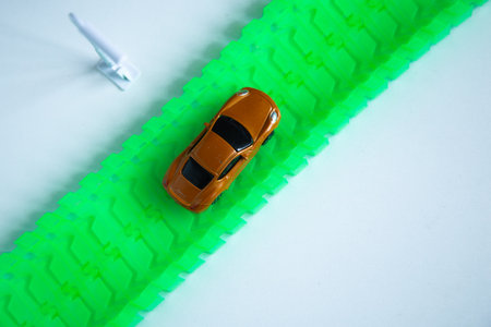 Toy car on a road with a syringe on a white background