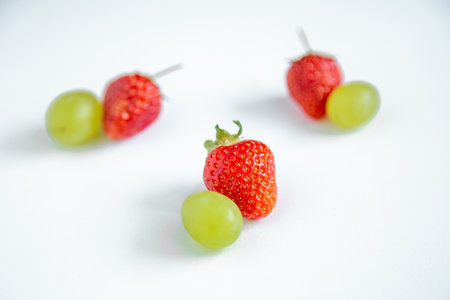 Strawberries and grapes on a white background. Close-up.の写真素材