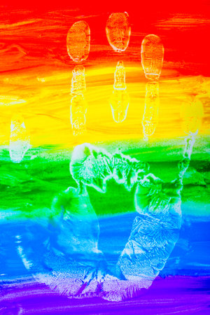 Colorful lines drawn horizontally with paint in the form of a rainbow with a handprint on a white background. LGBT PEOPLE. top view, flat lay, copy space, isolate.の写真素材