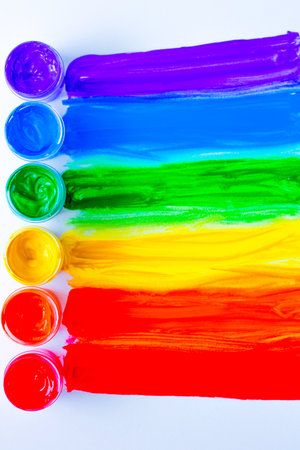 Colorful lines drawn horizontally from cans of paint in the form of a rainbow on a white background.. top view, flat lay, copy space, isolate.の写真素材