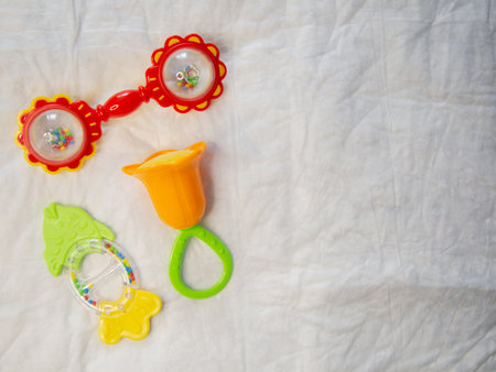 On a crumpled white background there are 3 rattles for newborns.の写真素材
