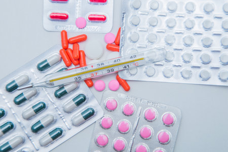 Tablets in capsules in packages and without lie on the entire surface of the photo with a...