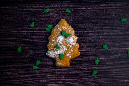 Cookies in the form of a Christmas tree sprinkled on top of white flour and small green Christmas...