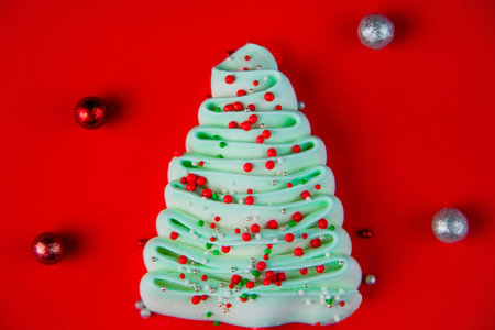 Turquoise bizet Christmas tree studded with colorful powder balls on a bright red background. High quality photoの写真素材
