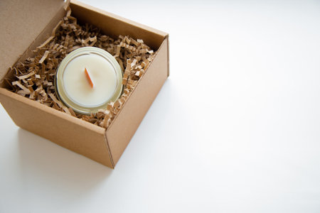 An open box with candles in a glass flask stands on a white background, close-up photo with space for text. High quality photoの写真素材