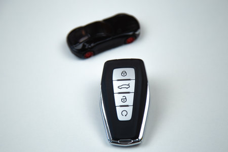 The car keys are black with metal inserts and automatic opening and closing buttons lying on the...