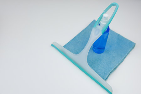 Use a squeegee along with a spray bottle and a cloth to achieve effective results in window cleaningの写真素材