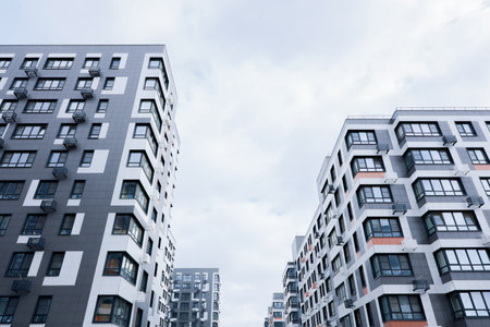 Contemporary residential buildings set against overcast gray skies, intricately reflecting the urban lifestyleの写真素材