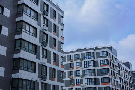 A striking view of contemporary apartment buildings under a cloudy sky, showcasing urban architecture.の写真素材