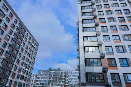 An urban landscape that beautifully showcases contemporary apartment buildings set against a vibrant, clear blue skyの写真素材