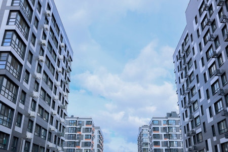 A captivating view of modern residential buildings under a blue sky, showcasing contemporary urban design.の写真素材