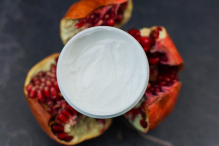 A vibrant and appealing image showcasing creamy yogurt beautifully nestled among bright pomegranate halvesの写真素材