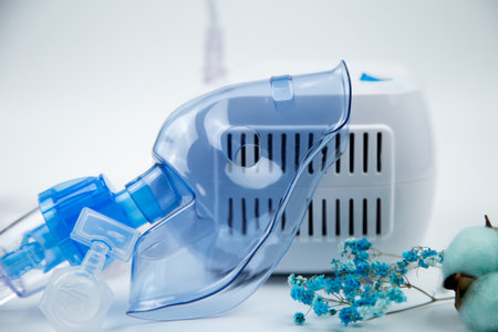 Close-up of the breathing blue mask of the inhaler lying against the background of the device, next...