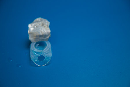 Close-up of a disposable container with a contact lens on a blue background with space for text. The concept of vision correction, ophthalmology. High quality photoの写真素材