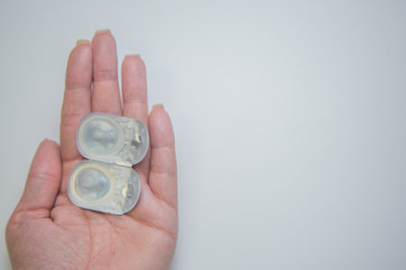Close-up of one-day contact lenses in disposable protective packaging on a white background lie in the palm of your hand. The concept of eye moisturizing, ophthalmology, vision correction, eye care. High quality photoの写真素材