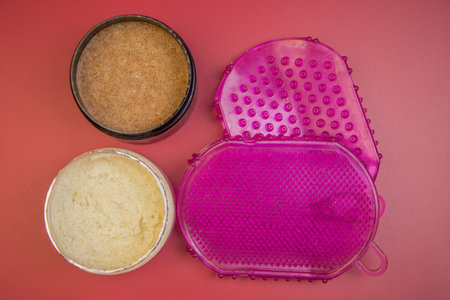 Vibrant containers filled with natural body scrubs, displaying rich textures and colors, arranged on...