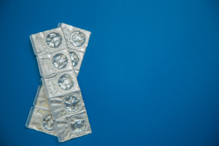 Packages of daily disposable contact lenses in a disposable protective case in which clear lenses float lie on the side on a blue background with space for text. The concept of ophthalmology, vision correction, eye care. High quality photoの写真素材