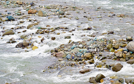 Beautiful view of various, colored stones in a mountain, fast riverの写真素材