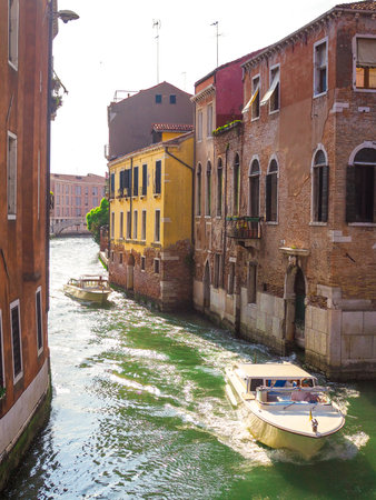 Cozy street in Venice with canals and gondolas, the tourist season in Italyの写真素材