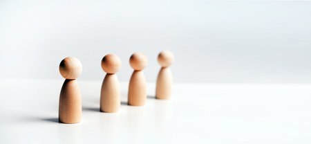Abstract wooden toy figures stand in a row on a white background. Concept of employees in a teamの写真素材
