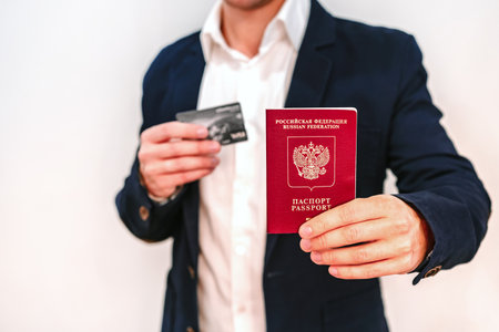 A business man in a jacket holds a Russian passport and a Bank cardの写真素材