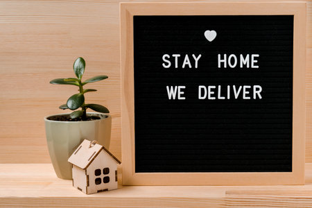 Social media message sign with text for social distancing awareness "STAY HOME WE DELIVER". Staying at home concept for product delivery companiesの写真素材