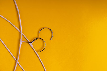 Clothes hangers are on a yellow background, top view. The concept of fashion