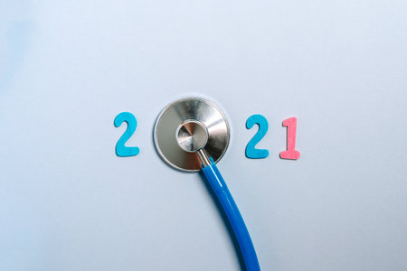 Stethoscope with the numbers 2021 on a blue background. Christmas for the health and medical banner or cover of the calendar. Creative idea.の写真素材