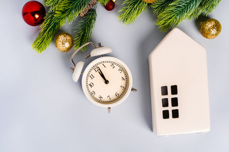 Christmas composition with alarm clock and ceramic Scandinavian house with Christmas decorations....