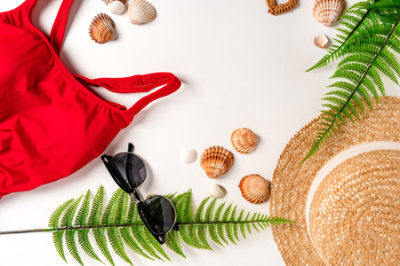 A set of accessories and a women's swimsuit are on a white table. Background for travel and...