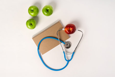 Stethoscope and keyboard at the doctor's workplace, apples as a health concept. White background, space for text.の写真素材
