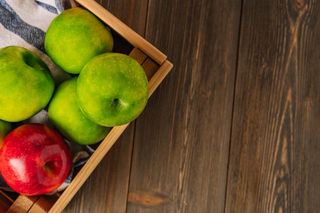 Green apples and one red one are laid out on a white tableの写真素材