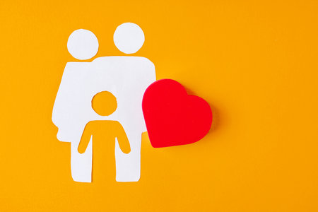 White paper family with parents and one child on a yellow backgroundの写真素材