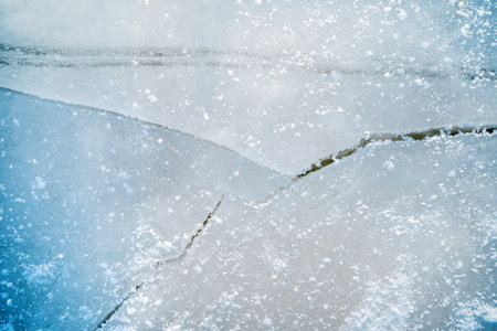 Ice on the snowy surface of an icy river, winter backgroundの写真素材