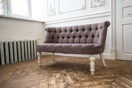 Vintage riveted fabric sofa in a bright interiorの写真素材