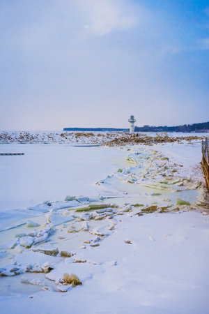 Lighthouse on a winter day on a frozen snow-covered river. Beautiful winter landscapeの写真素材