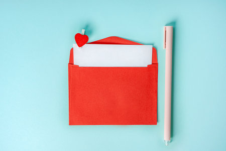 Love envelope with a clothespin in the shape of a heart on a blue background. Romantic background,...
