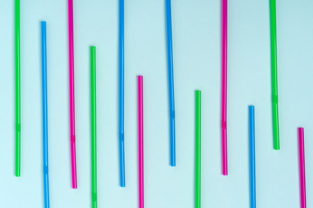 A pattern of colored beverage tubes laid out on a blue background
