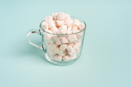 White marshmallow in a glass mug on a blue background. World diabetes day concept.の写真素材