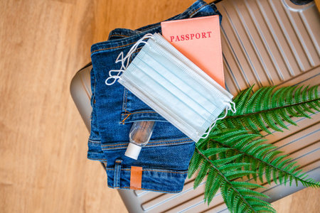Travel passports, a hat and medical masks are on the travel suitcase. Tourism after the opening of borders, the end of quarantineの写真素材
