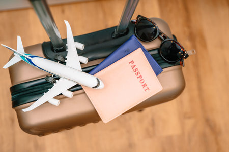 Tourist passports, a toy airplane on a travel suitcase. Conceptual photo of a tourist tripの写真素材