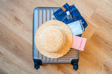 Travel passports, a hat and medical masks are on the travel suitcase. Tourism after the opening of borders, the end of quarantineの写真素材