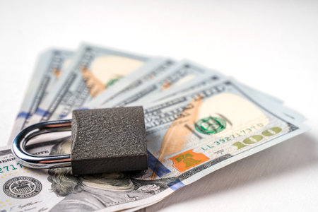 Locked lock on banknotes as a concept of financial security of deposits and money storageの写真素材