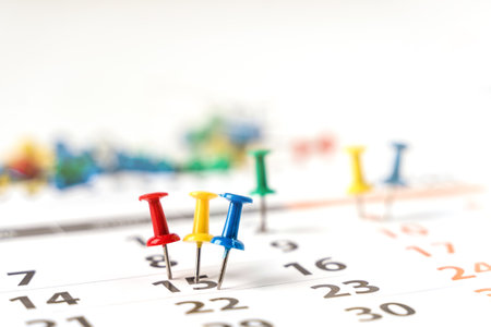 Lots of colorful pins on the calendar close-up with selective focus. The concept of planning.の写真素材
