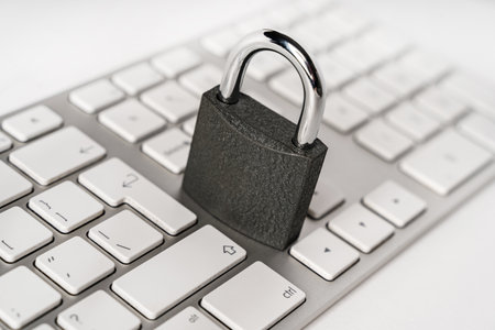 Concept of a computer security. Locked padlock on a white laptop keyboard.