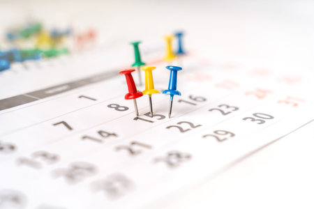 Lots of colorful pins on the calendar close-up with selective focus. The concept of planning.の写真素材