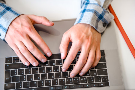Men's hands typing on a laptop keyboard, a business concept of working in the office as a programmer or manager in the business fieldの写真素材